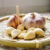 a basket of garlics and garlic bulbs on a counter